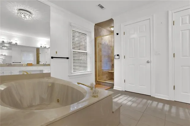 a spacious bathroom with a tub a double vanity sink and a mirror