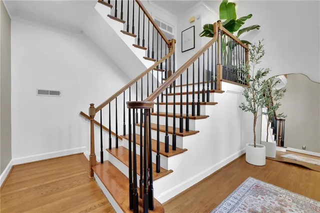 a view of staircase with wooden floor and a potted plant