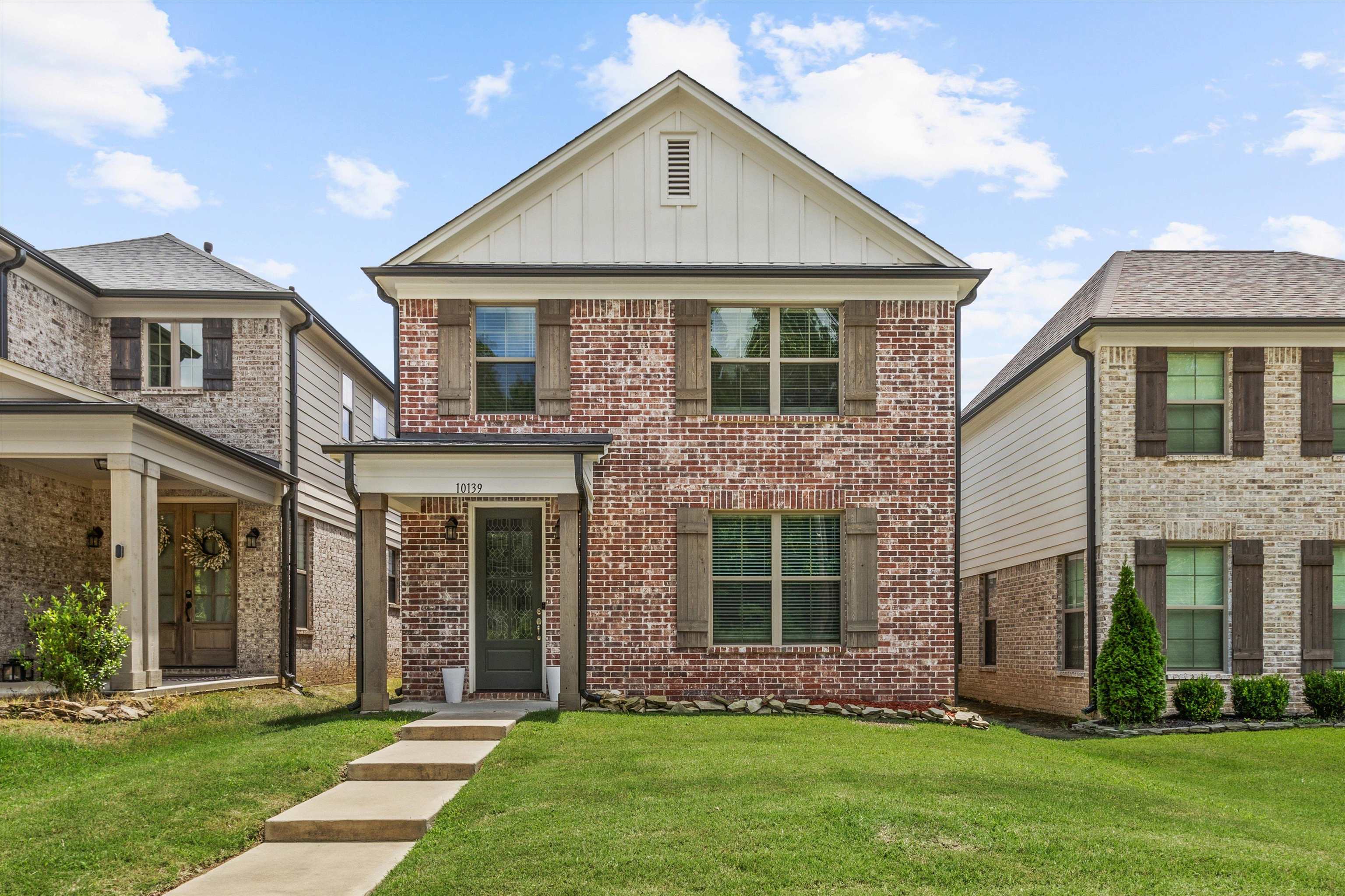 10139 Macon Road Cordova, TN 38018 - Photo 1 of 31 Brick exterior featuring wood shutters, white trim, and a covered entry with columns