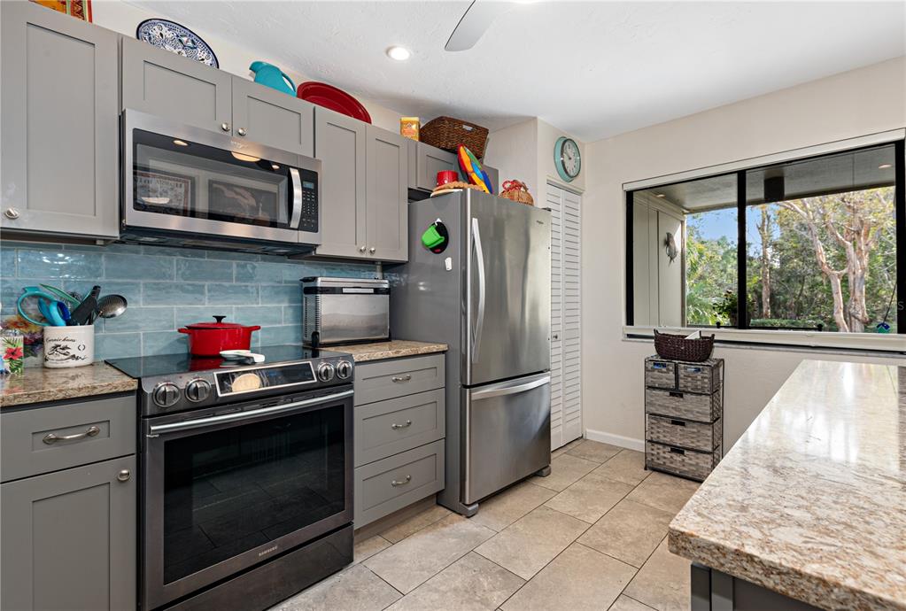 1512 Pelican Cove Road, Unit 239 Sarasota, FL 34231 - Photo 10 of 29 a kitchen with stainless steel appliances granite countertop a stove microwave refrigerator and sink