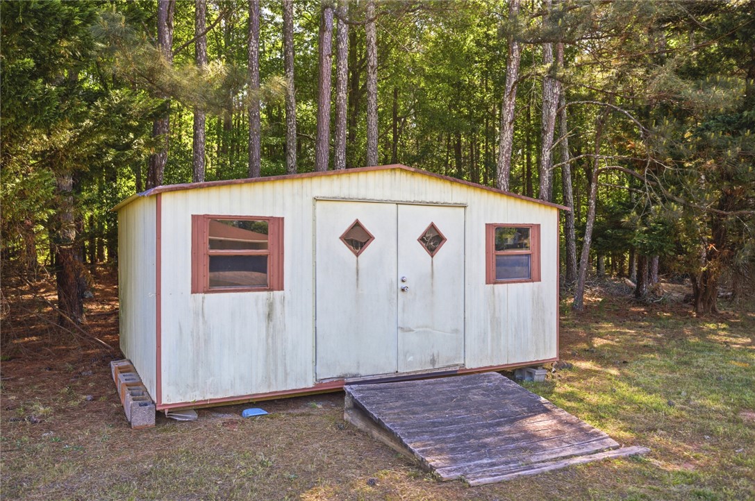 207 Greenmeadow Circle Anderson, SC 29626 - Photo 33 of 38 This charming shed offers practical storage solutions amidst a serene wooded setting.