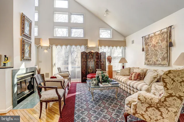 a living room with furniture fireplace and a large window