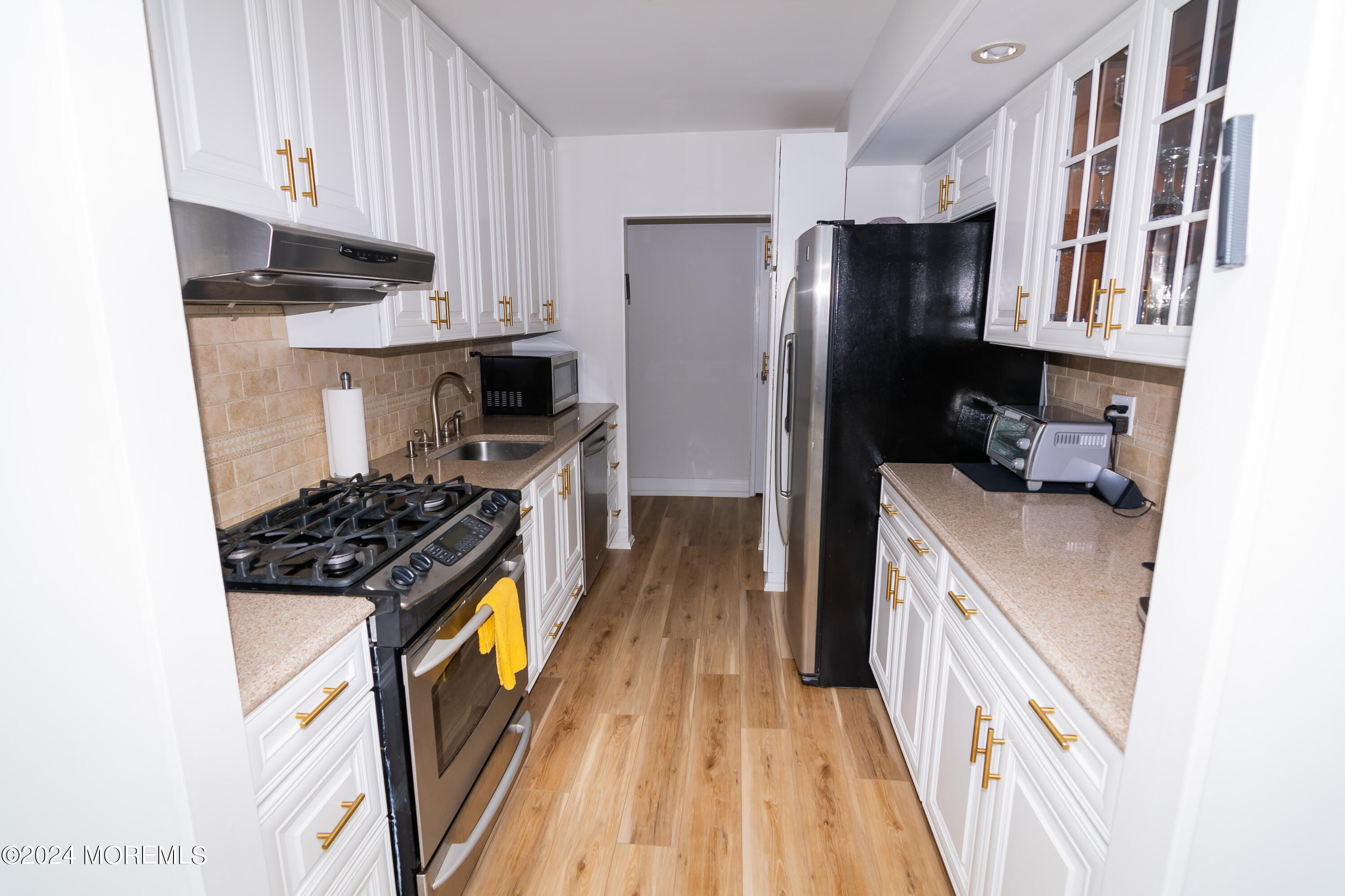 675 Ocean Avenue, Unit 3I Long Branch, NJ 07740 - Photo 13 of 35 a kitchen with stainless steel appliances granite countertop a stove a refrigerator a sink dishwasher and wooden cabinets with wooden floor