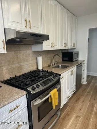 a kitchen with granite countertop a stove and a microwave
