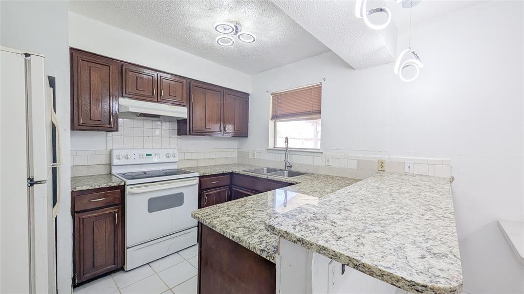 1107 Waverly Drive Arlington, TX 76015 - Photo 13 of 20 a kitchen with stainless steel appliances granite countertop a sink stove and cabinets