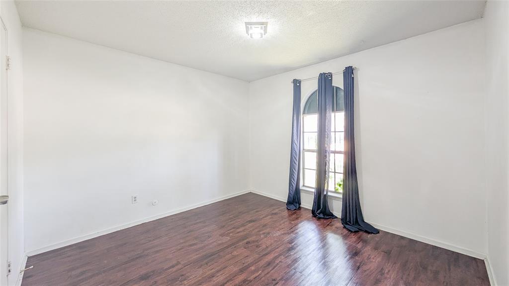 1107 Waverly Drive Arlington, TX 76015 - Photo 5 of 20 an empty room with wooden floor and windows