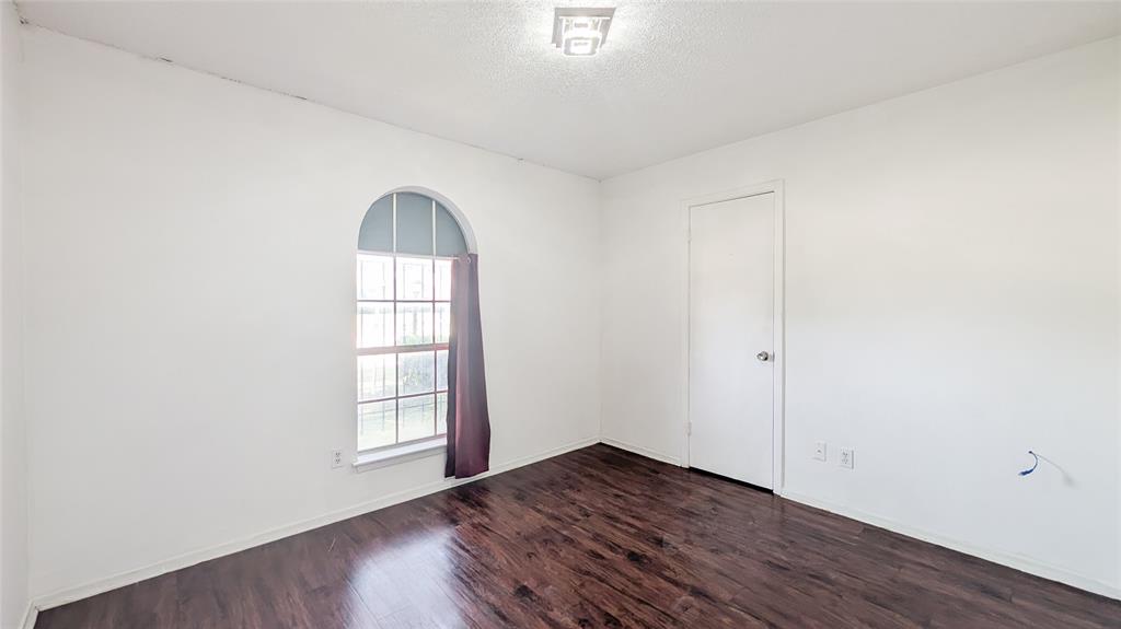 1107 Waverly Drive Arlington, TX 76015 - Photo 6 of 20 an empty room with wooden floor and windows