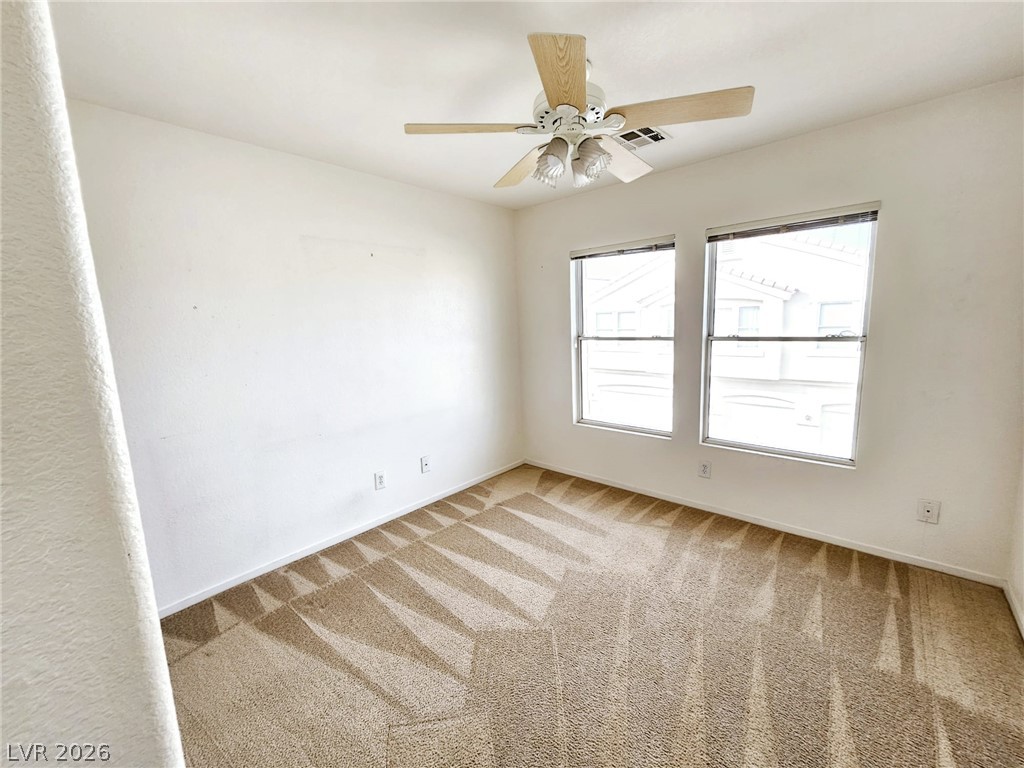 1663 Lefty Garcia Way Henderson, NV 89002 - Photo 12 of 31 Well-lit room with fresh carpeting and a practical ceiling fan.