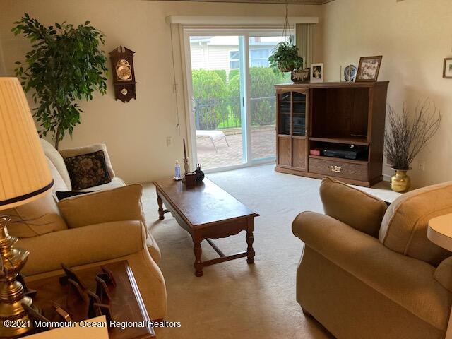 40 Rainier Drive Brick, NJ 08724 - Photo 15 of 25 a living room with furniture a flat screen tv and a floor to ceiling window