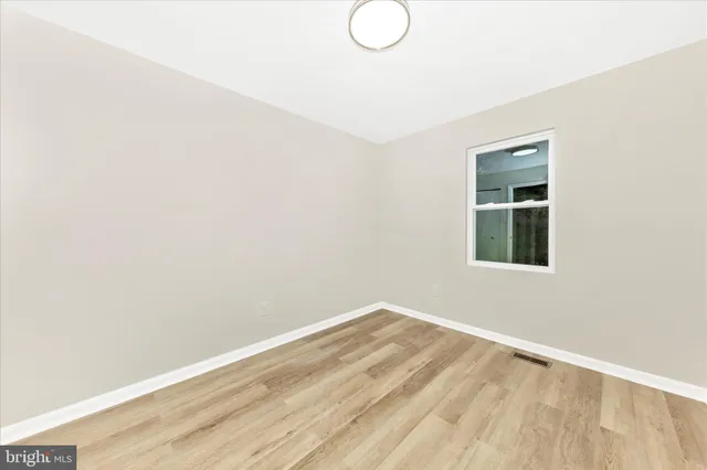 a view of a room with wooden floor and fan