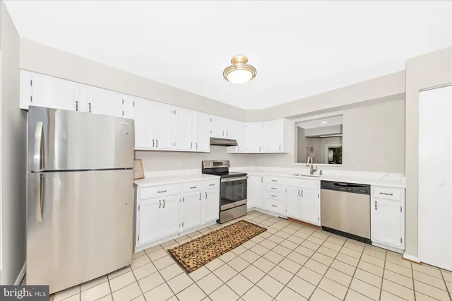 a kitchen with white cabinets and white appliances