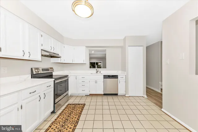 a kitchen with a sink a stove top oven and cabinets
