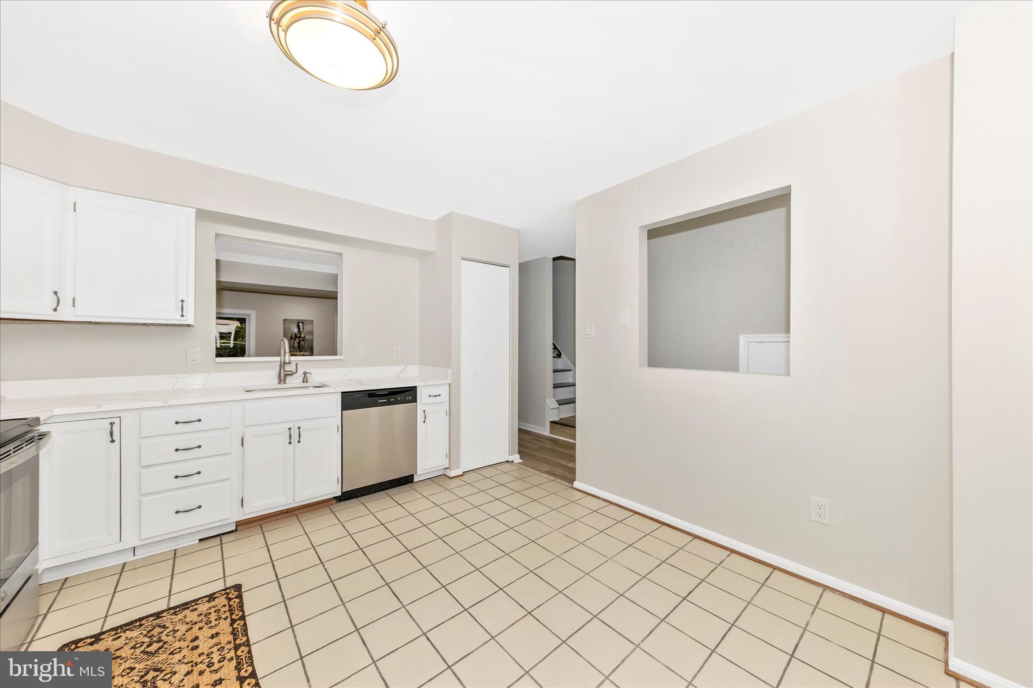 1 Kinsman View Circle Silver Spring, MD 20901 - Photo 6 of 52 a large white kitchen with white cabinets