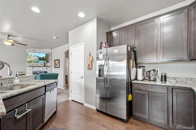 a kitchen with stainless steel appliances granite countertop a refrigerator a sink a stove a microwave and island