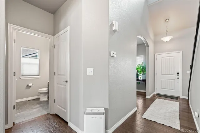 a view of a hallway with bathroom and wooden floor