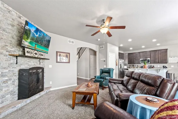 a living room with furniture a flat screen tv and a fireplace