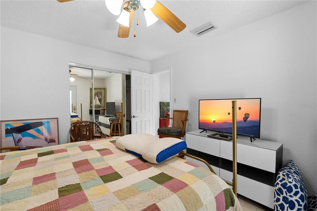 5122 Bay Boulevard Port Richey, FL 34668 - Photo 41 of 56 a bedroom with a bed and a flat tv screen on dresser