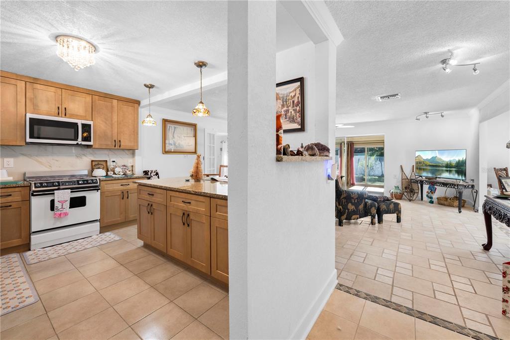 5122 Bay Boulevard Port Richey, FL 34668 - Photo 5 of 56 a kitchen with stainless steel appliances granite countertop a stove top oven a sink a dining table and chairs