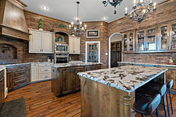 a kitchen with stainless steel appliances granite countertop a stove a refrigerator a oven a sink with a dining table and chairs