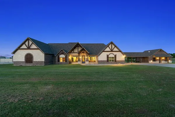 an aerial view of a house with a yard and trees