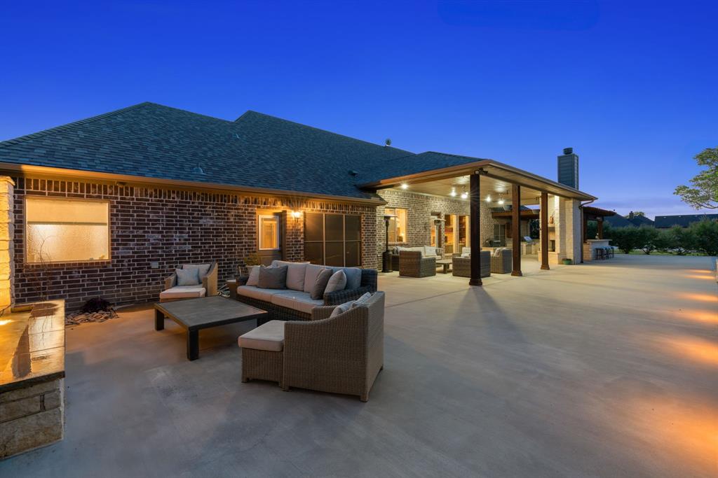 12190 Marion Road Sanger, TX 76266 - Photo 33 of 39 a view of a patio with couches and table and chairs under an umbrella