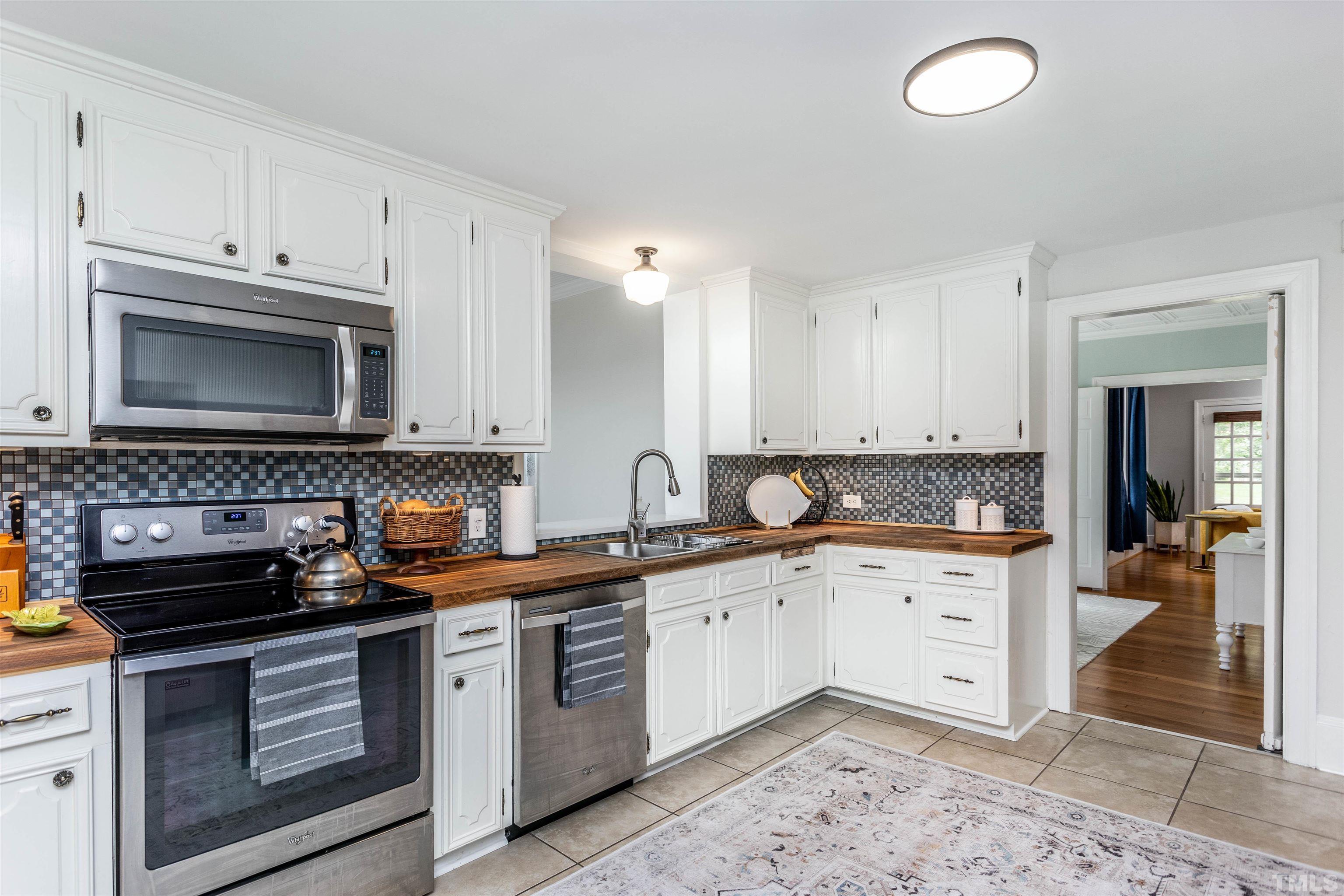 2019 New Bern Avenue Raleigh, NC 27610 - Photo 12 of 37 a kitchen with granite countertop a sink a stove top oven and cabinets