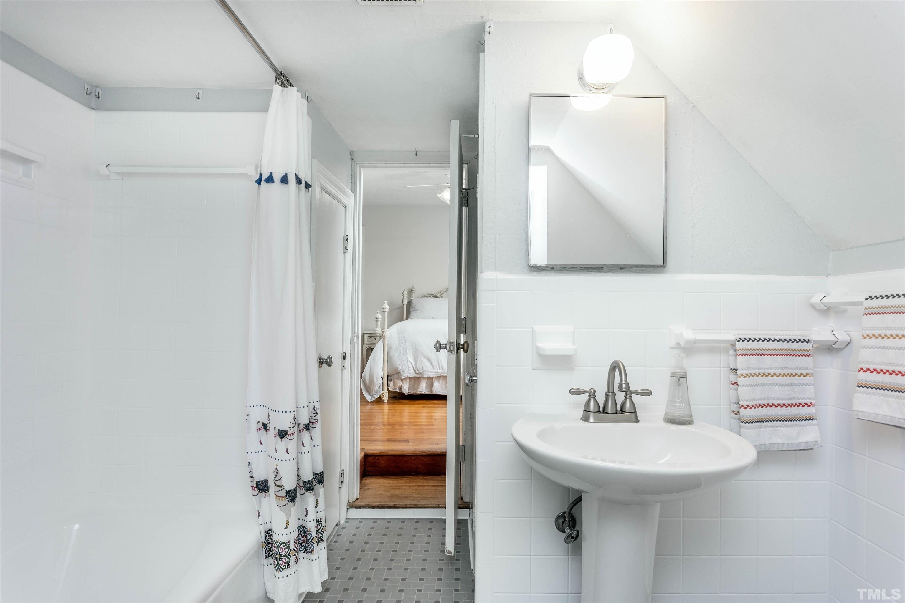 2019 New Bern Avenue Raleigh, NC 27610 - Photo 26 of 37 a bathroom with a sink a mirror and a shower