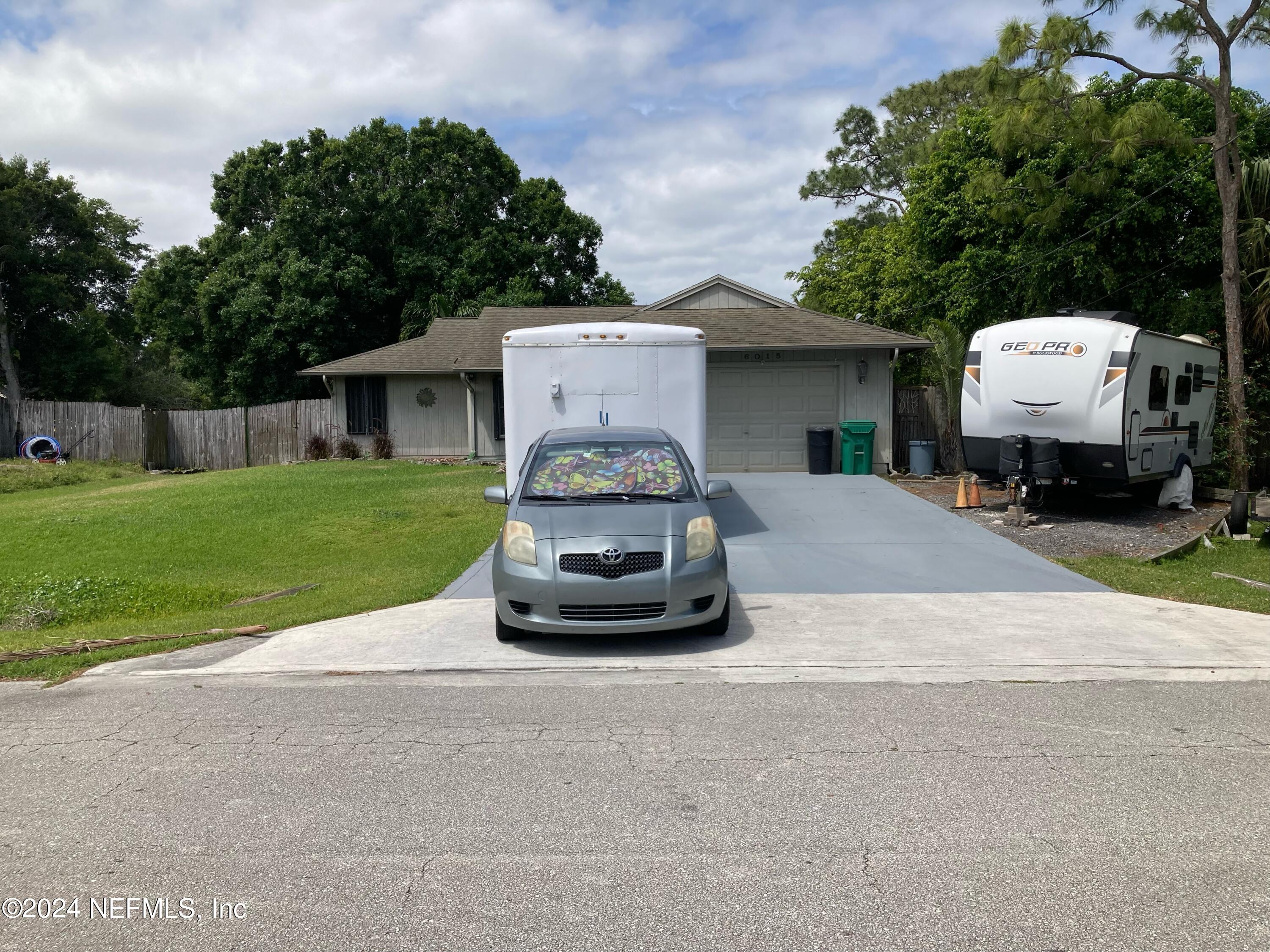 a car parked in front of a house with a yard