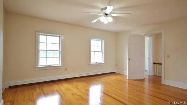 an empty room with wooden floor and window