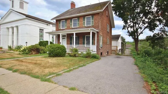 a front view of multiple houses with yard
