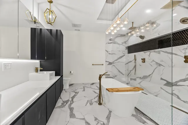 a bathroom with a sink a bathtub and a chandelier