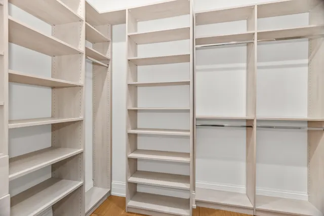 a view of walk in closet with empty racks