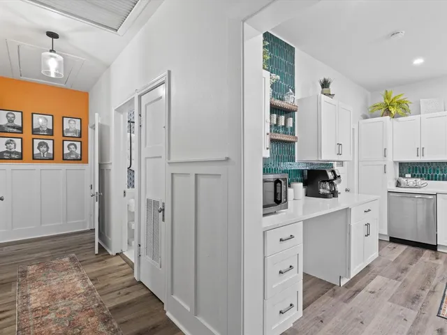 a kitchen with white cabinets and window