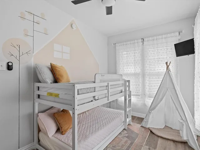 a bedroom with a bed and wooden floor