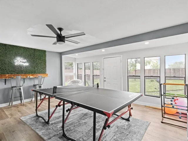 a living room with furniture pool table and a flat screen tv