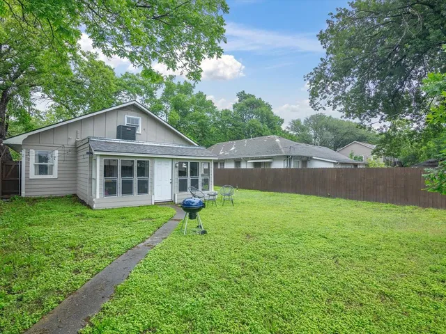 a backyard of a house with table and chairs
