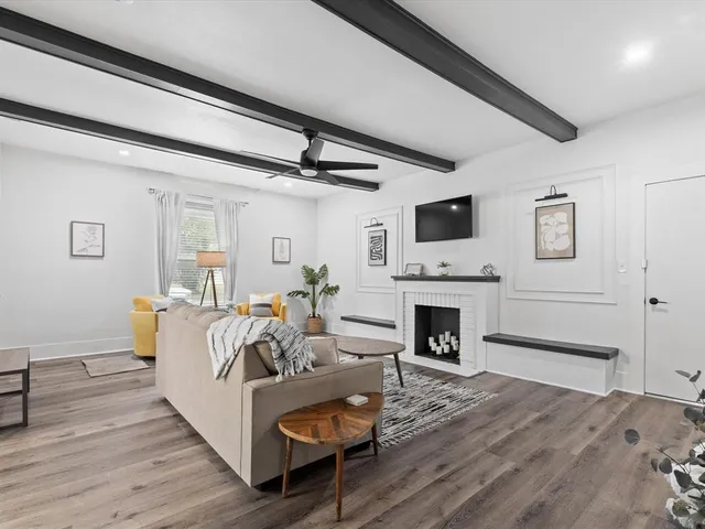 a living room with furniture a fireplace and a flat screen tv