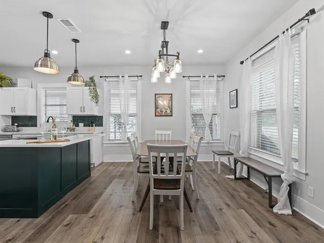 a kitchen with stainless steel appliances a dining table chairs stove and refrigerator