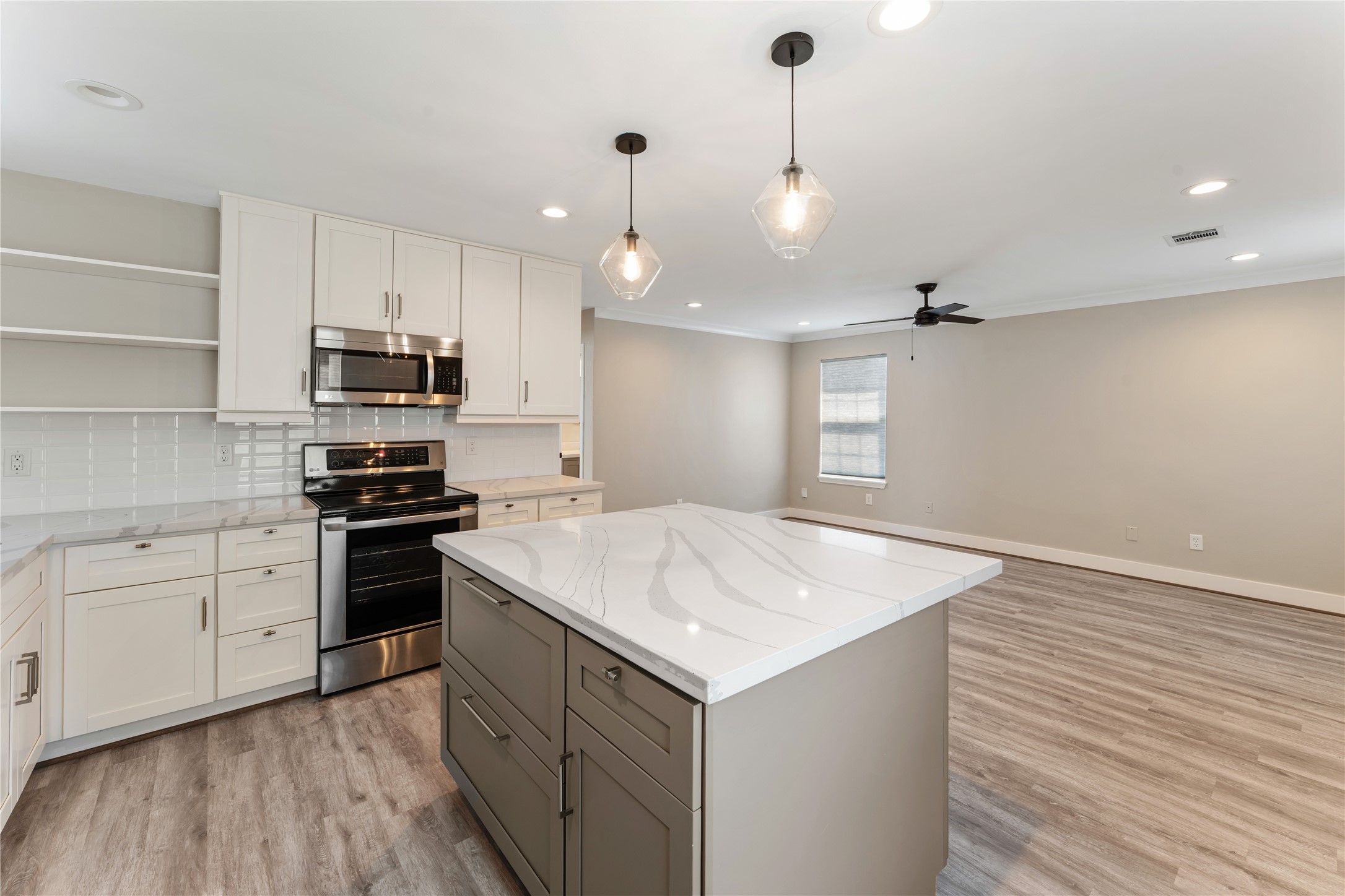 809 East 40th Street Houston, TX 77022 - Photo 10 of 27 Open-concept living connects the updated kitchen to a spacious living area, enhanced by new flooring and updated lighting throughout. Perfect for entertaining or everyday living with a clean, modern feel.