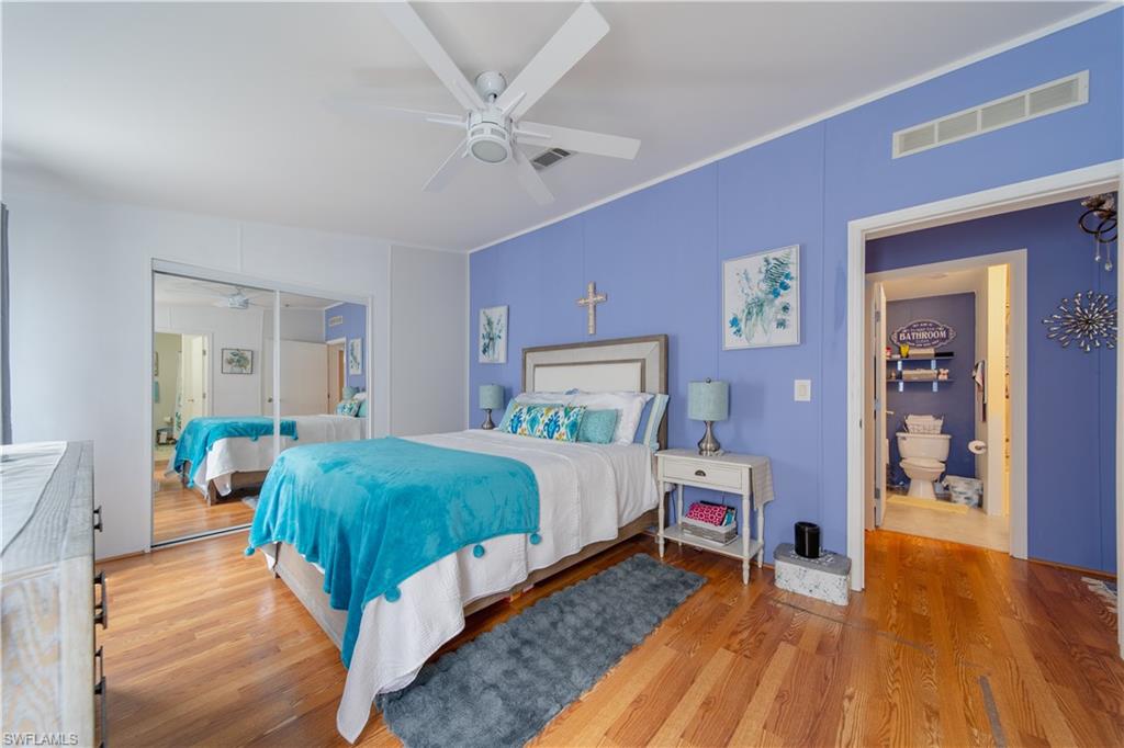 433 Riviera Boulevard West Naples, FL 34112 - Photo 12 of 30 a bedroom with a bed and wooden floor