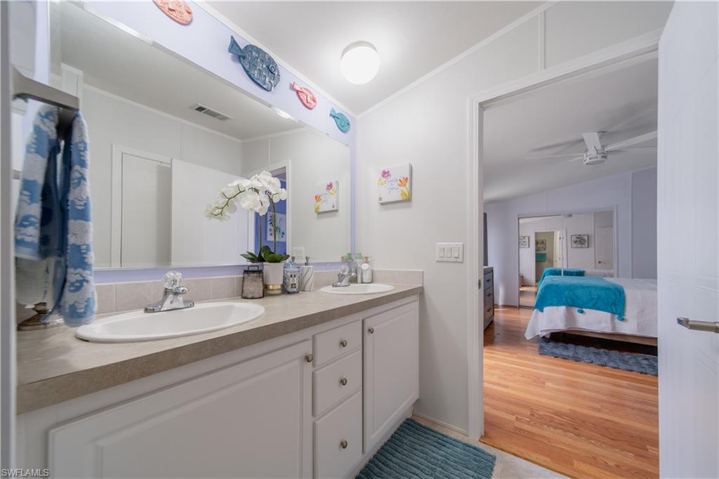 433 Riviera Boulevard West Naples, FL 34112 - Photo 14 of 30 a bathroom with double vanity and a mirror