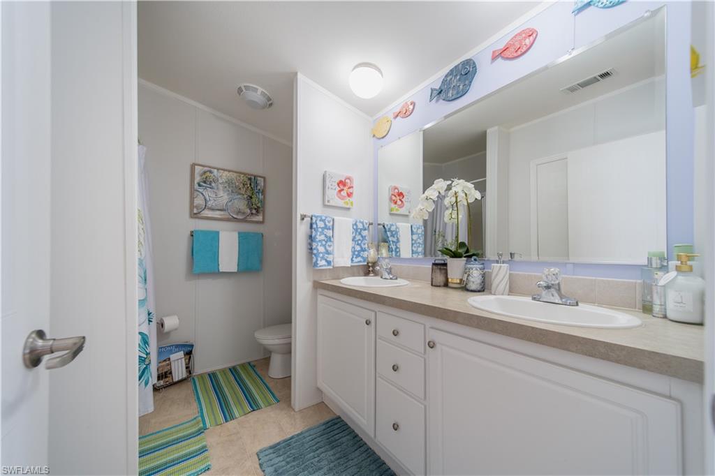 433 Riviera Boulevard West Naples, FL 34112 - Photo 15 of 30 a en suite bathroom with a double vanity sink a mirror and a shower