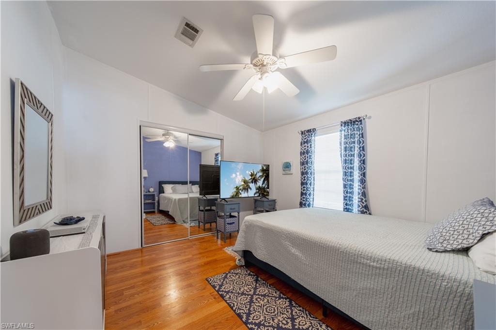 433 Riviera Boulevard West Naples, FL 34112 - Photo 17 of 30 a bedroom with a bed a window and a flat screen tv