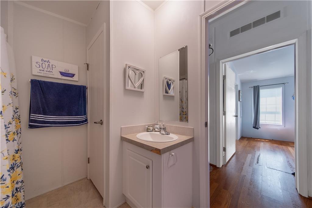 433 Riviera Boulevard West Naples, FL 34112 - Photo 18 of 30 a bathroom with a granite countertop sink and a mirror