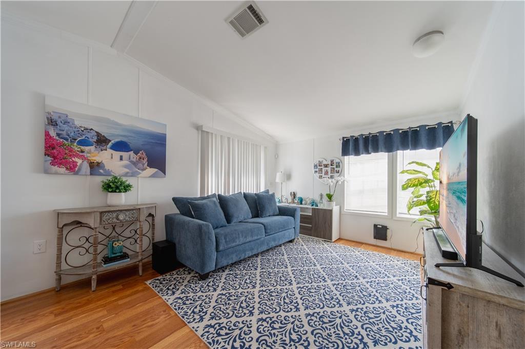 433 Riviera Boulevard West Naples, FL 34112 - Photo 3 of 30 a living room with furniture and a wooden floor