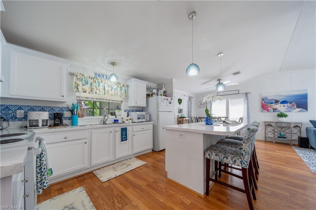433 Riviera Boulevard West Naples, FL 34112 - Photo 6 of 30 a kitchen with cabinets a sink and appliances