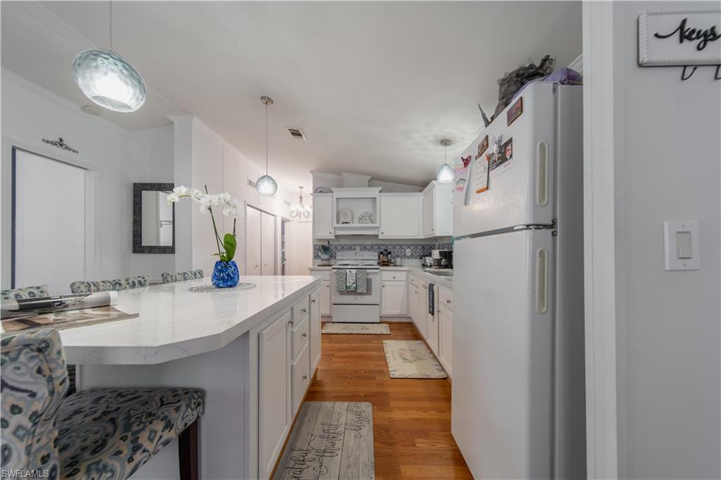 433 Riviera Boulevard West Naples, FL 34112 - Photo 7 of 30 a kitchen with kitchen island a sink appliances and cabinets