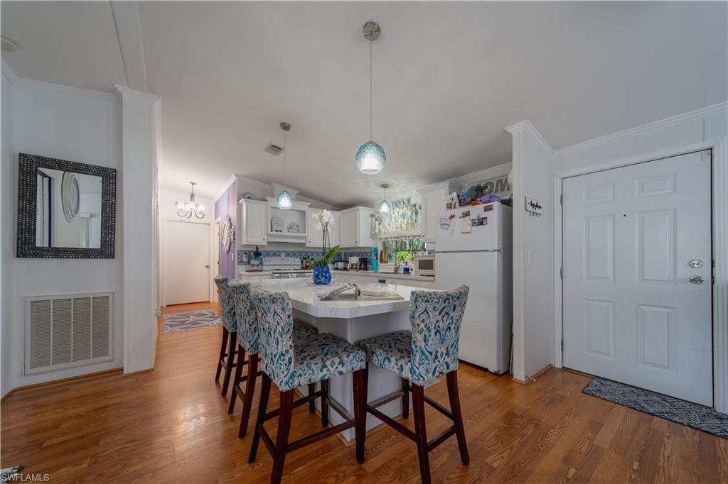 433 Riviera Boulevard West Naples, FL 34112 - Photo 8 of 30 a dining room with furniture and wooden floor