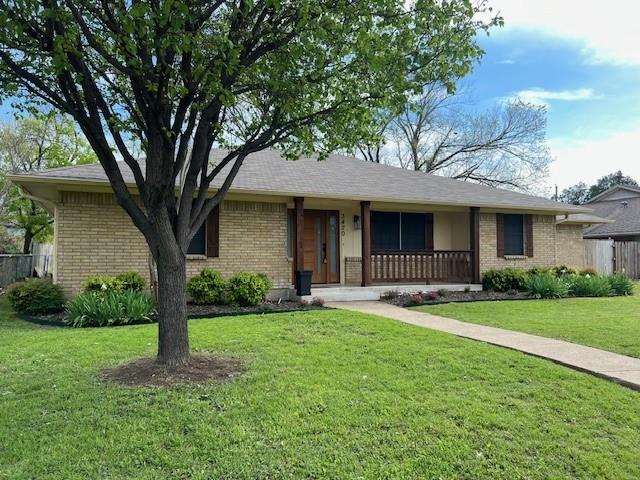 a front view of a house with a garden and trees