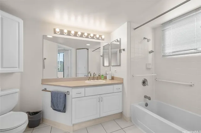 a spacious bathroom with a granite countertop sink a toilet mirror and bathtub